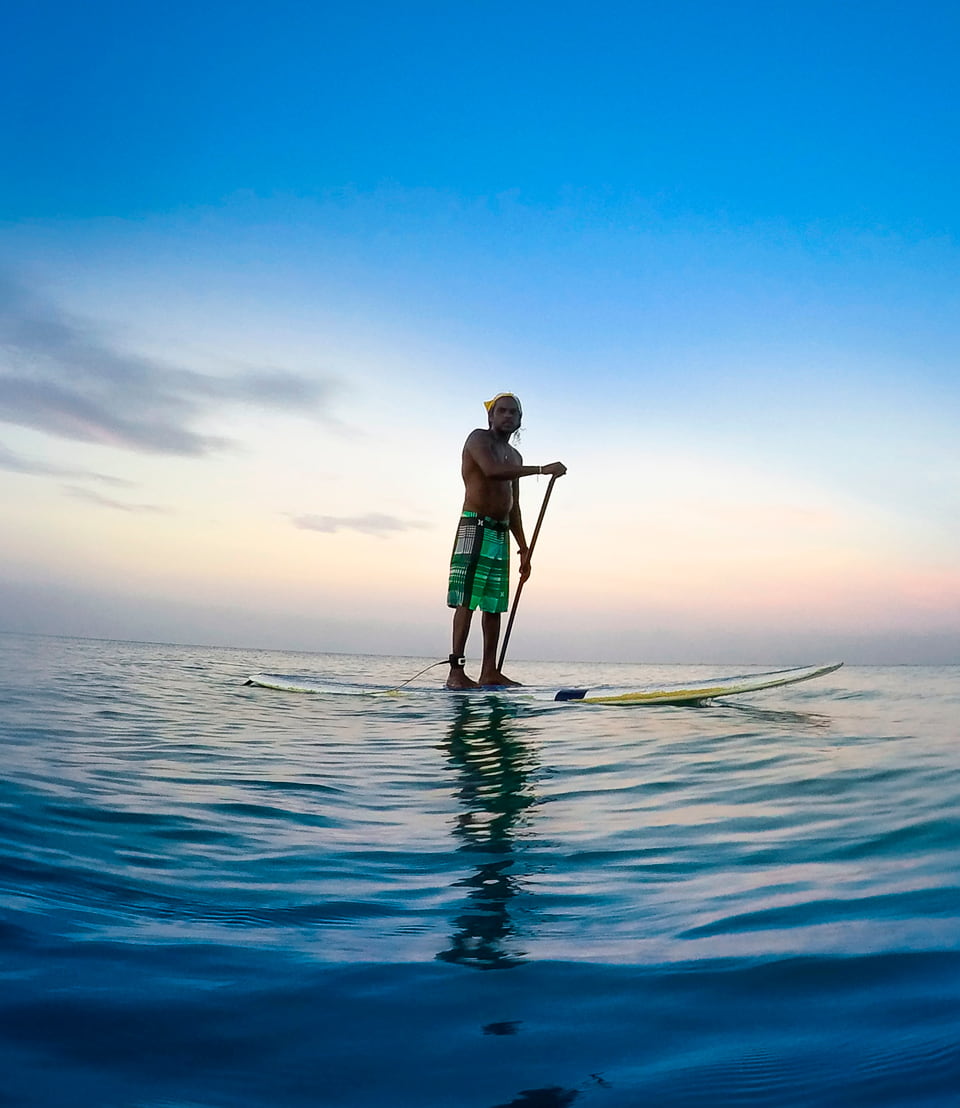 Un chico haciendo paddle surf en aguas tranquilas